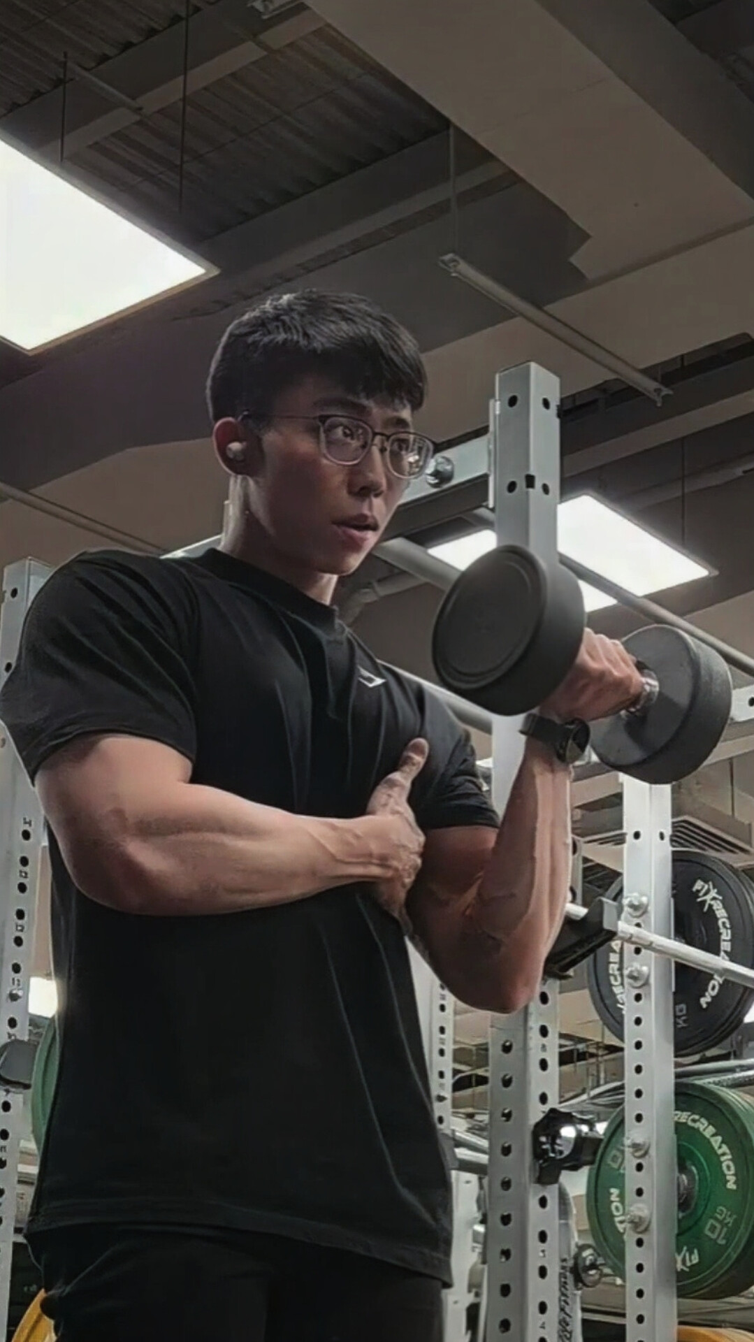 Client following an online coaching program at home with dumbbells and a phone